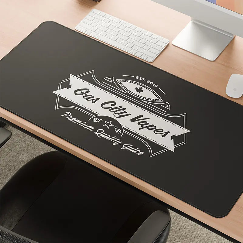 Black desk mat with 'Gas City Vapes' branding on a wooden desk.